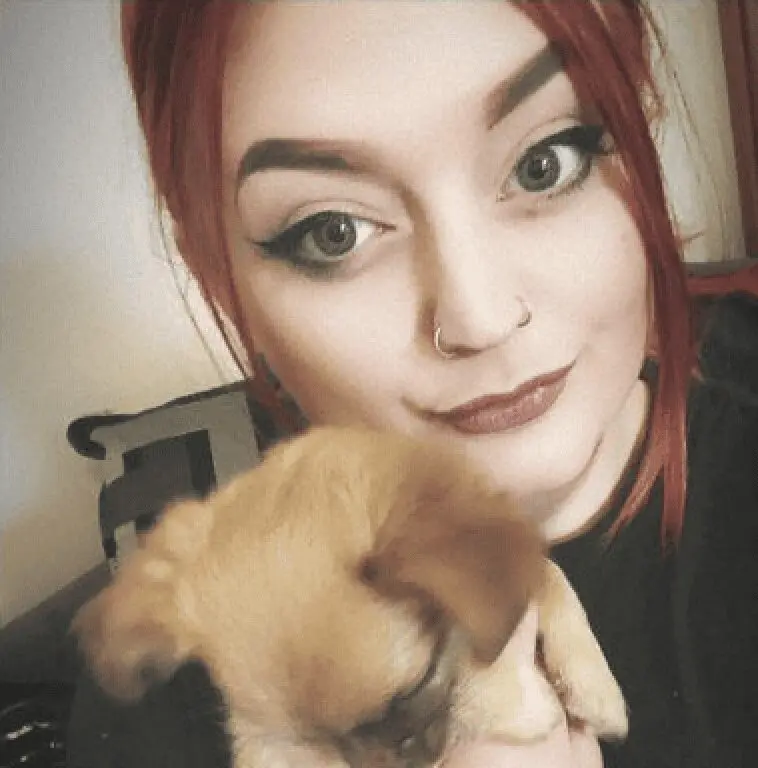 A photo of Paws2Rescue team member Abbey holding a very small dog
